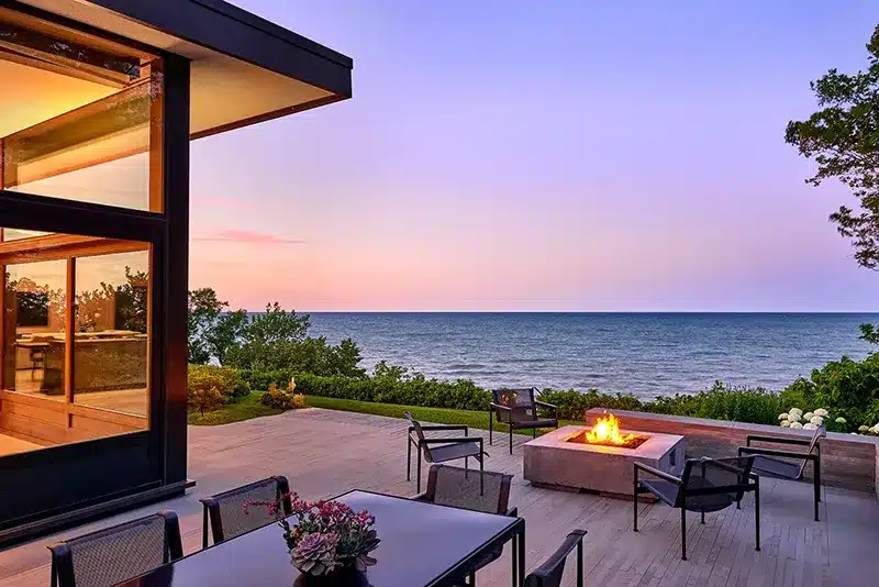 A large patio with a fire pit overlooking the ocean.