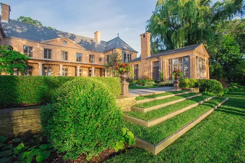 A large mansion with a large lawn and steps.