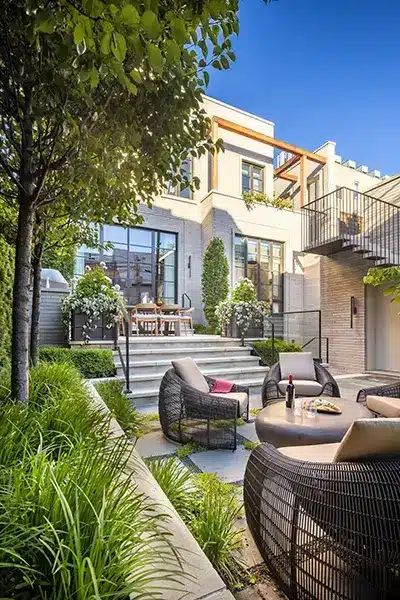 A modern backyard with wicker furniture and plants.