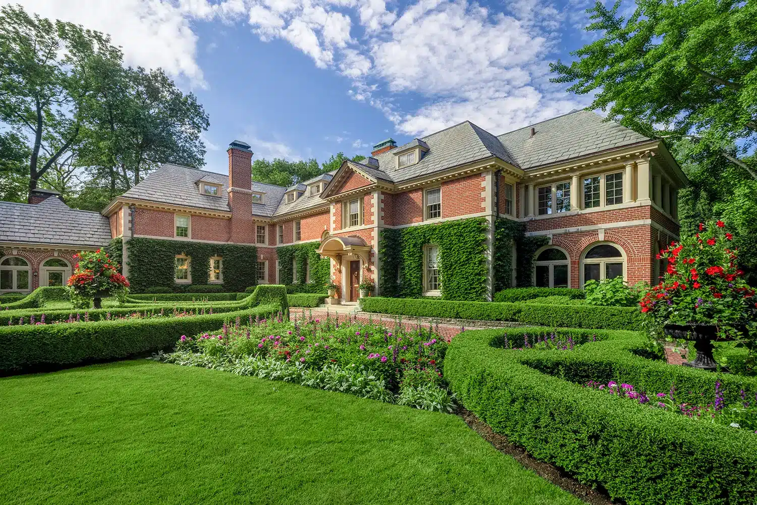 A large mansion with a lawn and hedges.