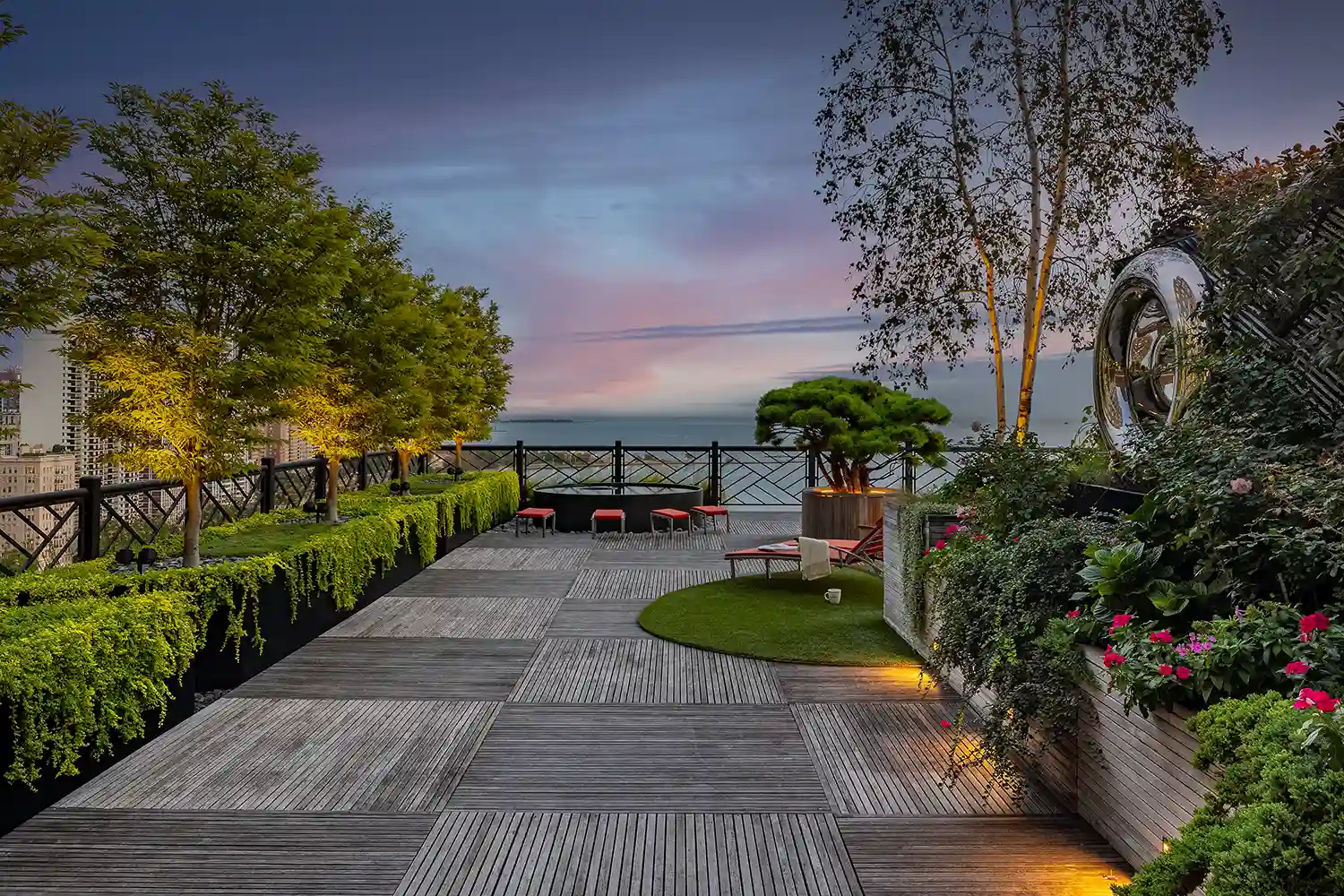 A wooden deck with a view of the ocean at dusk.