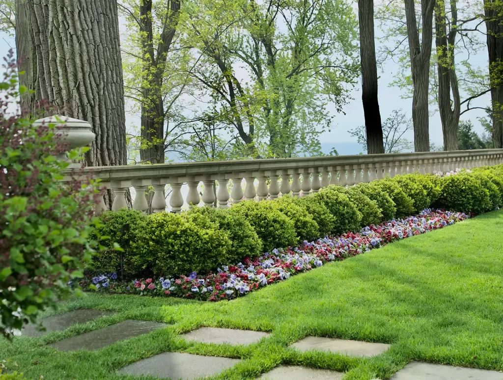 A garden with a stone wall and flowerbeds.