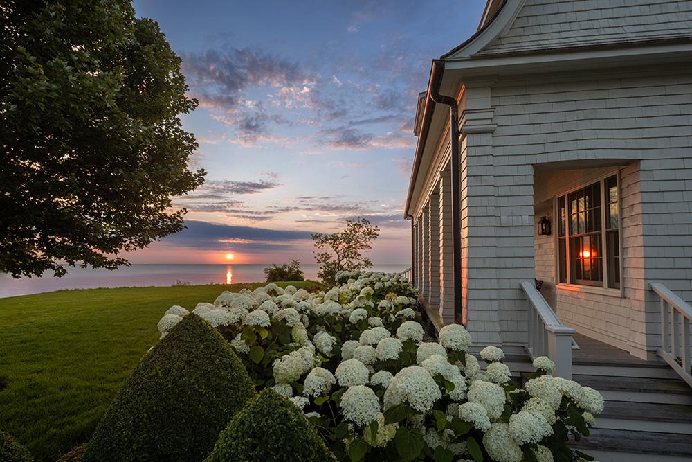 A white house with a view of the ocean.