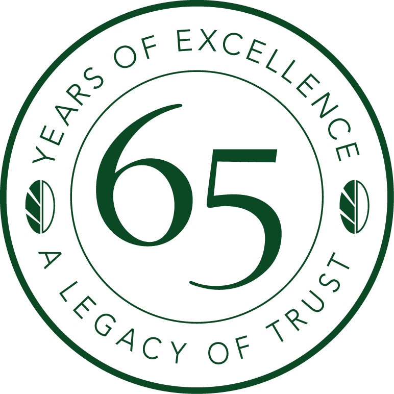 Circular logo with the number 65 in the center. Text around edge reads, "Years of Excellence" and "A Legacy of Trust" with leaf designs on sides.