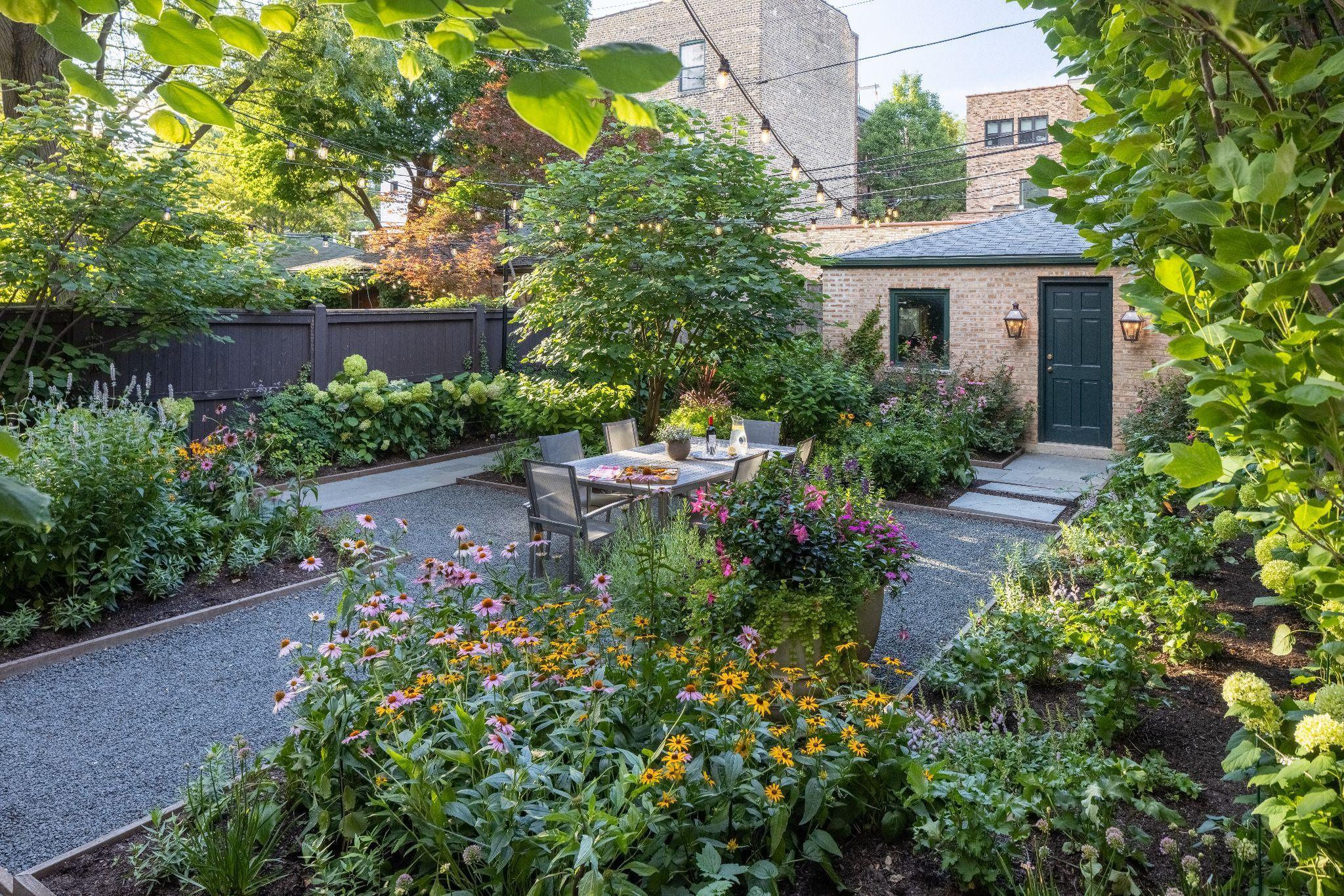 Private city garden with flowering perennials and gravel terrace