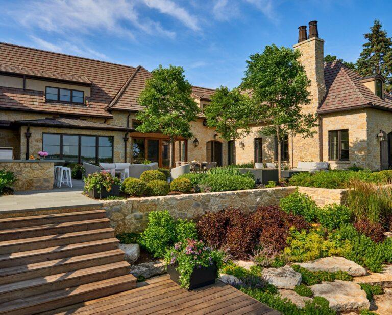Stone estate home with terraced landscaping and outdoor living area